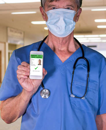 Male doctor concept of immunity testing and certification on smartphone app to allow people to go back to work after negative testの写真素材