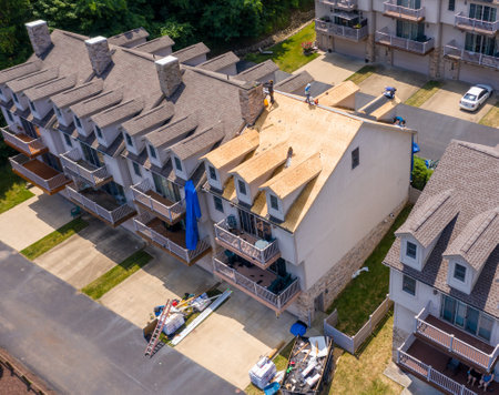Morgantown, WV - 7 July 2020: Aerial view of roofing contractors replacing the old shingles on a townhouse roofのeditorial素材