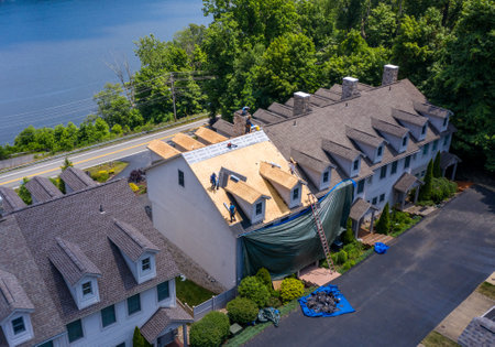 Morgantown, WV - 7 July 2020: Aerial view of roofing contractors replacing the old shingles on a townhouse roofのeditorial素材