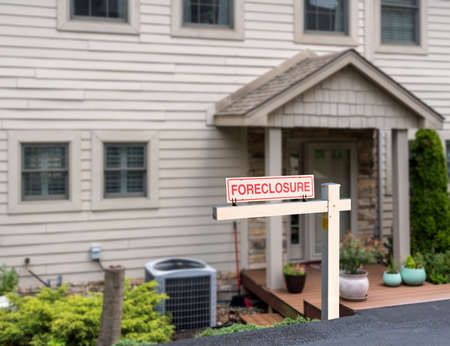 Mockup of a foreclosure sign in front of a modern townhome or townhouse to illustrate recession fears due to coronavirusの写真素材