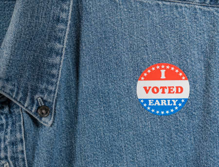 I Voted Early sticker or campaign button on the blue denim working shirt collar for elections in the USAの写真素材