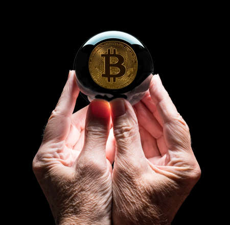 Crystal futures or fortune telling ball reflecting a Bitcoin coin as concept for predicting the future exchange rate for the currencyの写真素材