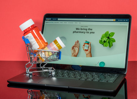 Morgantown, WV - 18 November 2020: Minature shopping cart holding prescription drugs in front of screen with Amazon Pharmacy landing pageのeditorial素材