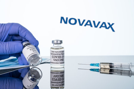 Morgantown, WV - 16 December 2020: Small bottle of coronavirus vaccine with syringe with background of Novavax logoのeditorial素材