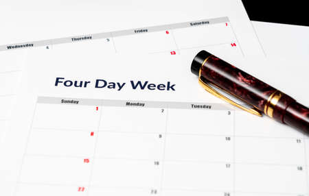 Printed calendar for a 4 day working week showing weekend days in red in new approach to productivityの写真素材