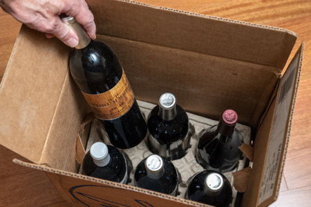 Morgantown, WV - 1 October 2021: Senior man looking at wine bottle from Scott Peterson out of box of six delivered from Naked Winesのeditorial素材