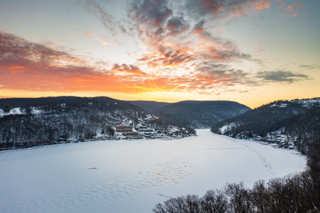 Aerial drone panorama of spectacular sunrise over the frozen and snow-covered Cheat Lake looking...