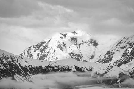 Monochrome image of the misty mountains that are the source of the Hubbard Glacier in Alaskaの写真素材