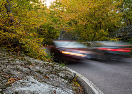 Cars meet between narrow bend between boulders in Smugglers Notch in the fall