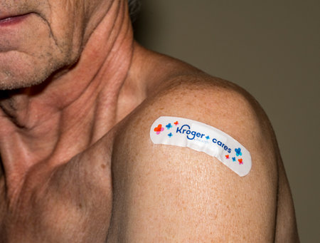 Morgantown, WV - 20 October 2022: Senior man with Kroger covering over flu or covid shot in shoulder