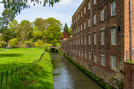 Exterior of restored cotton spinning and weaving mill in north of England with riverの写真素材