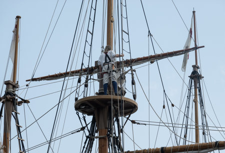 Sailor on lookout deck after climbing the rigging of replica sailing ship that sailed to America