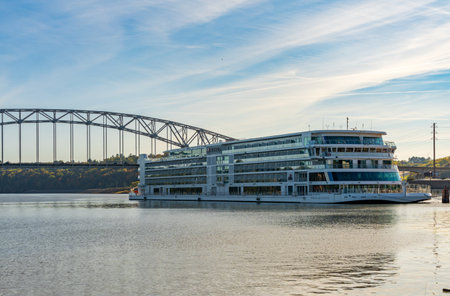 Dubuque, IA - 17 October 2023: Viking Mississippi river cruise boat docked by modern road bridge on Mississippi river in Iowaのeditorial素材