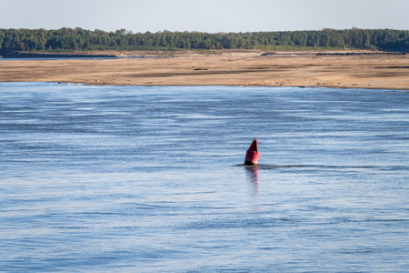 Extreme low water conditions on Mississippi river in October 2023 with red buoy marking river channel in Missouriの写真素材