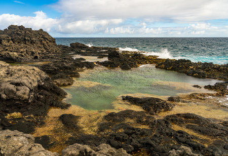Tidal pools on the lava rock plateau near Kilauae point on north coast of Kauaiの写真素材