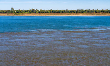 Confluence of the blue Ohio river and brown Mississippi river at Cairo, Illinois with blue and brown muddy streams starting to mixの写真素材