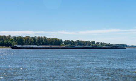 Large tug boat pushing rows of barges with grain products up the Mississippi river south of Cairo in Illinoisの写真素材