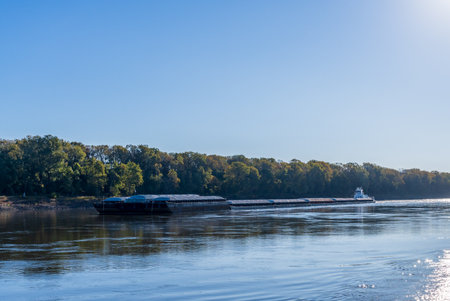 Large tug boat pushing rows of barges with grain products up the Mississippi river south of St Louis in Missouriの写真素材