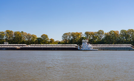 Large tug boat pushing rows of barges with grain products up the Mississippi river south of Cairo in Illinoisの写真素材