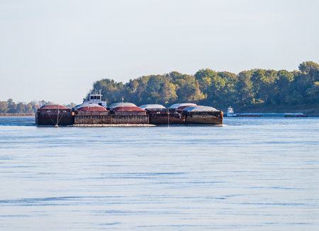 Freight barges approaching over the calm waters of the Mississippi river during low water conditionsの写真素材
