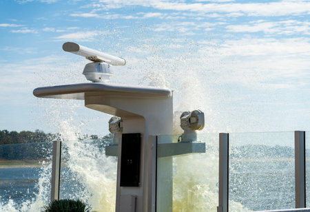 Spray and wave from passing freight barge creates splash onto deck of a modern Mississippi river cruise boatの写真素材