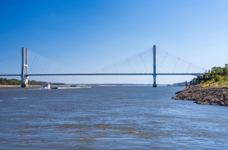 Modern cable-stayed suspension bridge, the Jesse Brent Memorial bridge across the Mississippi river near Greenville with river bargeの写真素材