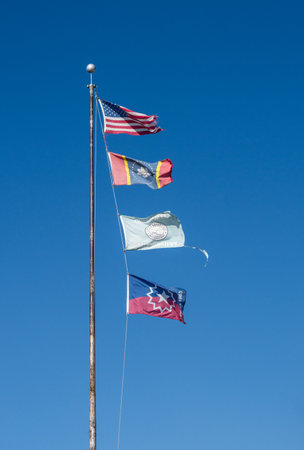 Flagpole with USA and Mississippi state flags, Greenville City flag and Juneteenth Flag in the town in Mississippiの写真素材