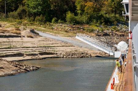 Modern Mississippi river boat starts to dock with gangway on river bank with steep sandy side in Arkansasの写真素材