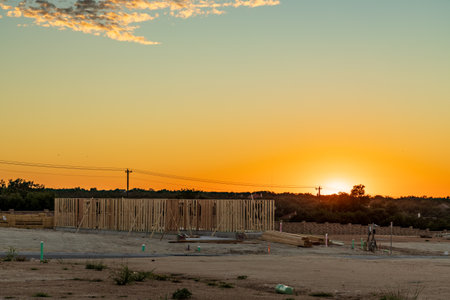 Single family home with slab foundations and dimensional lumber frames and framing creating the structure of the house at sunset in Georgetown Texasの写真素材