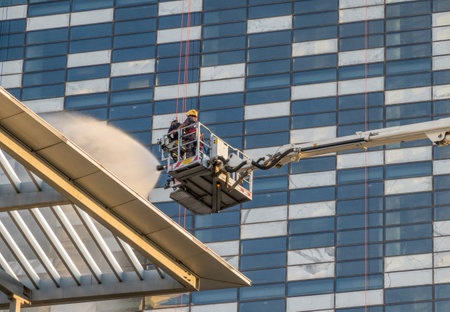 Fire men spraying water during fire fighting emergency exercise on modern office building in Amman, Jordanの写真素材