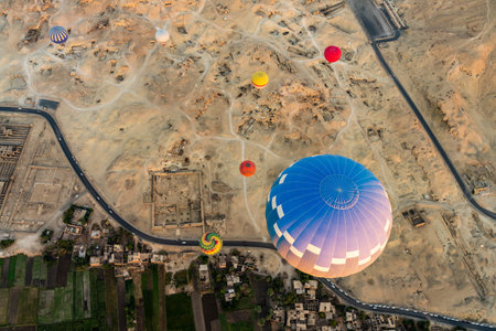 Large hot-air balloon rising from ground over Sahara desert and Valley of Kings near Luxor, Egpytの写真素材