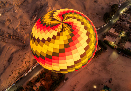 Large hot-air balloon rising from ground over desert and near Luxor, Egyptの写真素材