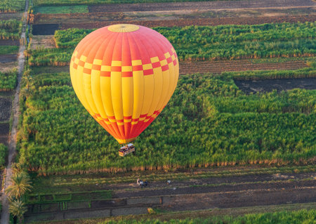 Large hot-air balloon descending to farmland near Luxor, Egyptの写真素材