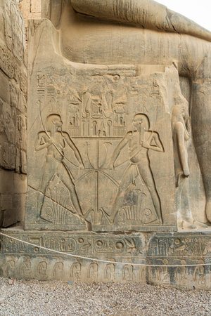 Engravings on base of massive stone statue of Ramesses II stands in Luxor templeの写真素材
