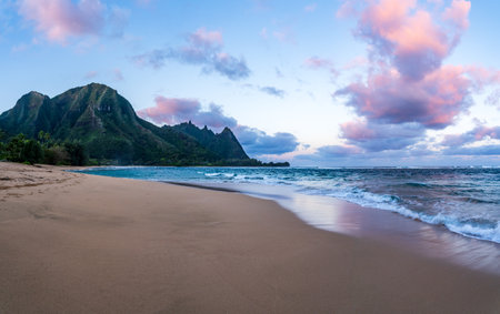 Beautiful Tunnels Beach at dawn on the island of Kauai, Hawaii with the vibrant sky reflecting on the wet sand.の写真素材