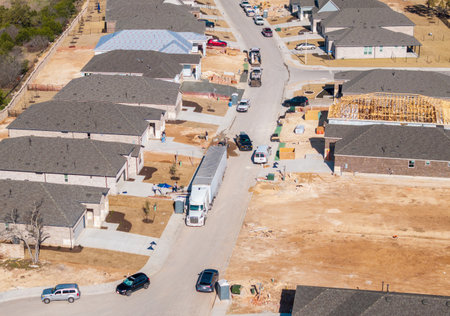 Aerial view of a moving truck unloading boxes in a new suburban neighborhood in Georgetown, Texas, during a sunny day.の写真素材