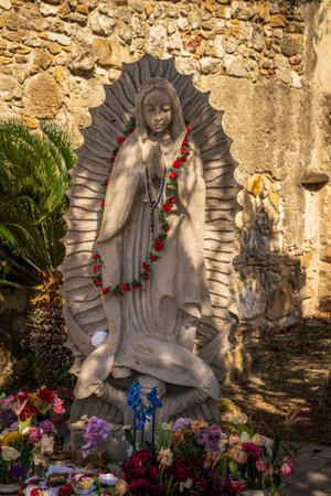 San Juan mission church is a historic landmark near San Antonio, Texas with small statue of Virgin Mary with flowersの写真素材