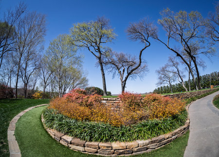 A gently curving grass path edged with stone leads towards a scenic overlook, surrounded by spring...