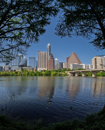 Fisheye lens view of Austin skyline including bridge over the calm waters of Colorado river in Texasの写真素材