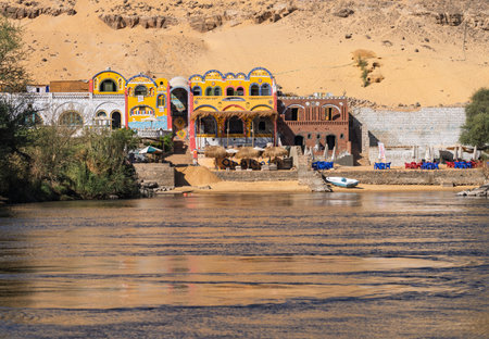 Fast flowing waters of River Nile with colorful Nubian hotels near Aswan in Egyptの写真素材