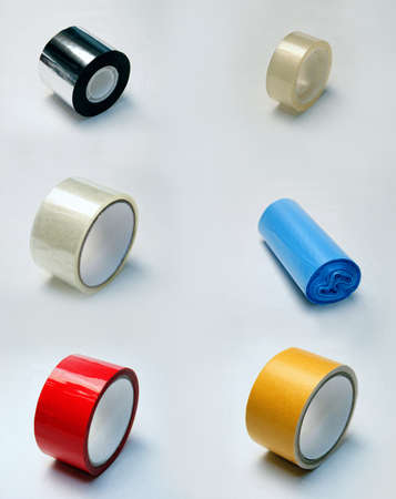 tape of different colors and garbage bags. Collection of adhesive tapes in red, silver, yellow, transparent and blue colors on white backgroundの写真素材