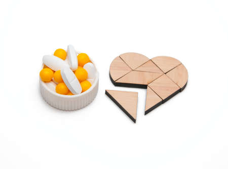 yellow and white tablets near the heartの写真素材