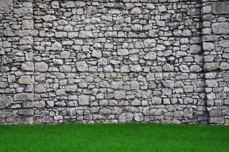 old stone wall and green grassの写真素材