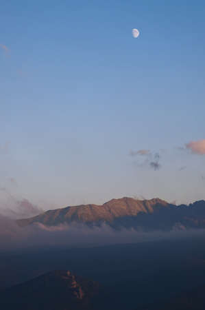 moon over the mountains in the blue sky