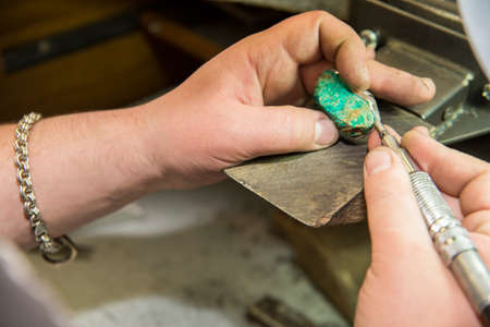 jeweler attaches green stoneの写真素材