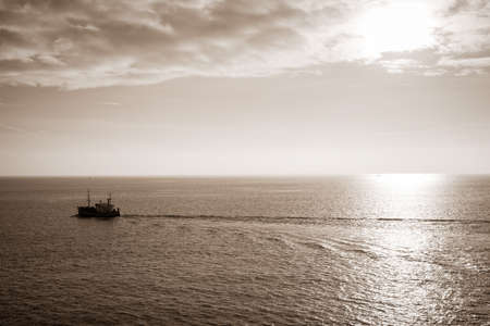 little lone ship at sea at sunsetの写真素材