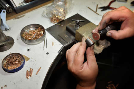 jeweler makes jewelery in the workplace