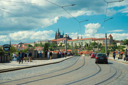 PRAGUE, CZECH REPUBLIC - MAY 6, 2015: Tourists walk over the bridge to the old townのeditorial素材