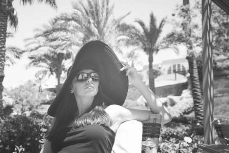 fashionable girl in the big black hat and sunglassesの写真素材