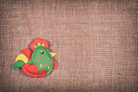 toy rooster on a brown fabric background